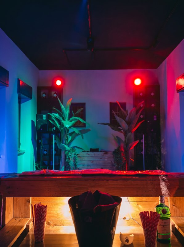 Il bancone bar acceso di rosso e blu, pronto per il servizio
