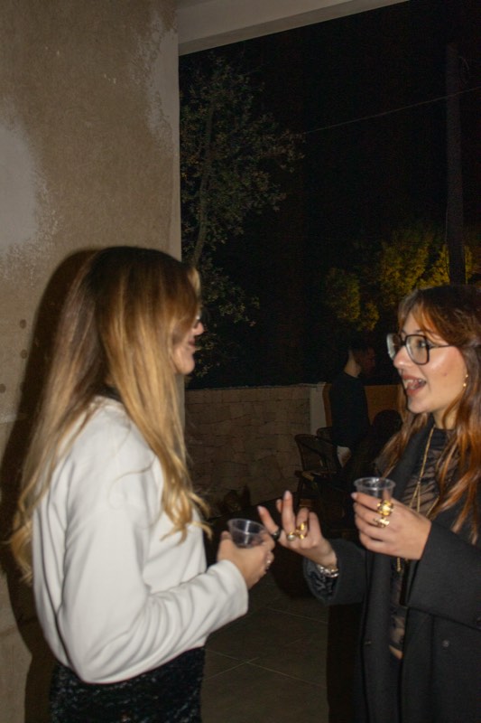 Due ospiti che chiacchierano con un drink in mano
