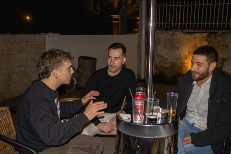 Ospiti seduti al tavolo nella corte esterna con la stufa accesa